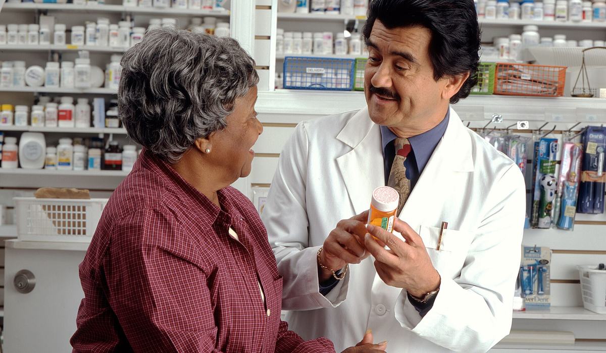 Pharmacist counseling a patient about a prescription and coverage
